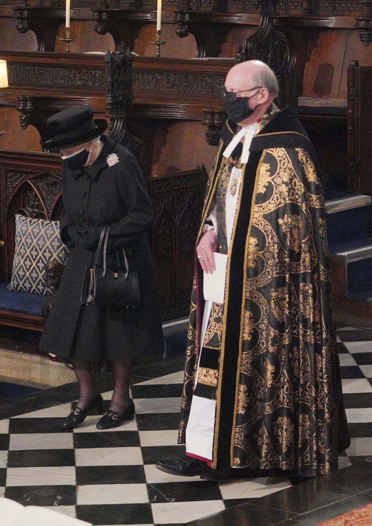 Britain's Queen Elizabeth is conducted by the Dean of Windsor into the Quire of St George's Chapel in Windsor Castle, Windsor, England, Saturday April 17, 2021.