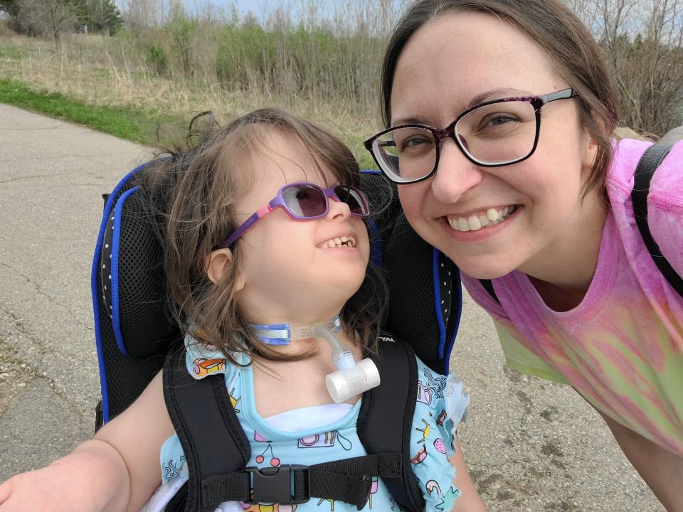 Mimi Ludwig, 6, gazes up at her mother, Melissa Fox at a Grand Rapids-area park in April 2023. Mimi was born with Trisomy 18, a rare congenital chromosomal disorder.