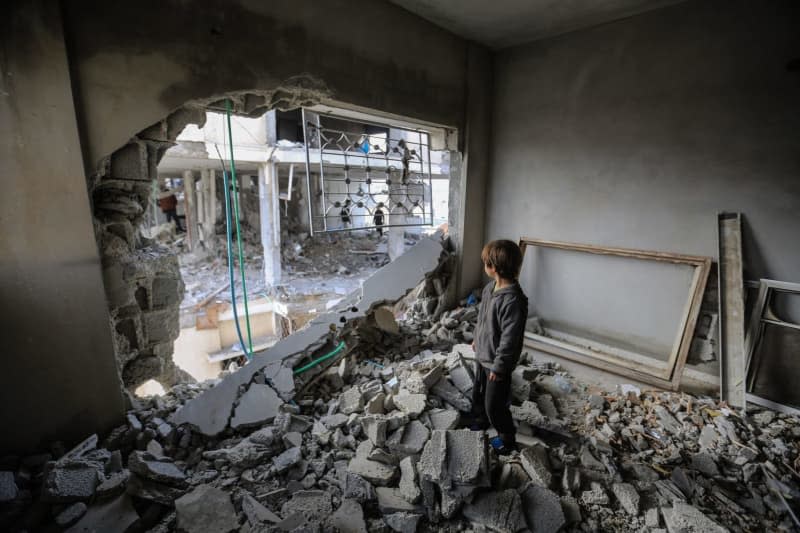 A Palestinian child inspects the damage and rubble of destroyed homes following Israeli airstrikes on several homes in the city of Rafah. Mohammed Talatene/dpa