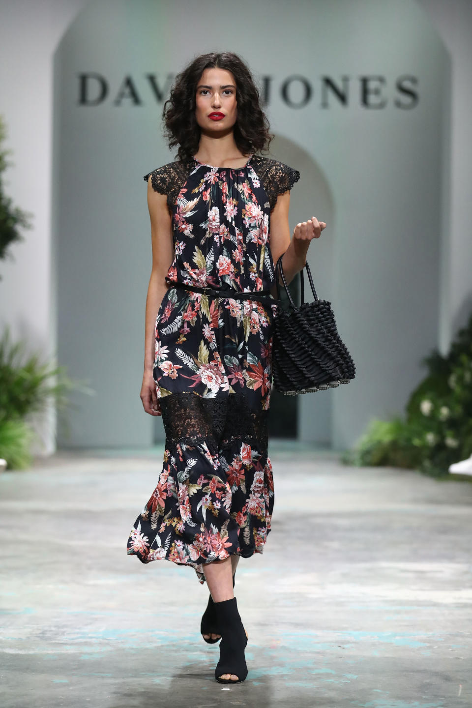 <p>This model looked pretty in a black and floral cal-lenghth dress, which was matched with black heels and a tote bag. Photo: Getty Images </p>