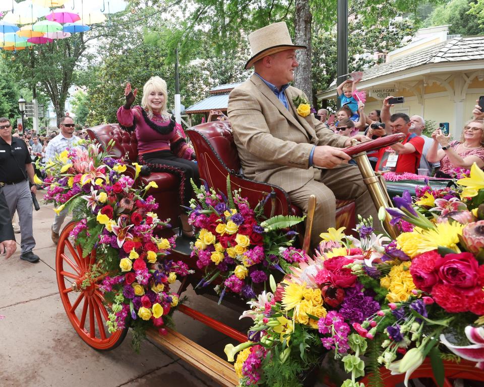 Dolly Parton waves to fans during a parade at Dollywood on May 12, the day Big Bear Mountain opened at the park. Barring rain or extreme cold, parades are held when she visits, so all guests have the opportunity to see her.