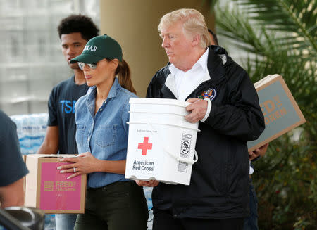 U.S. President Donald Trump and first lady Melania Trump help volunteers deliver supplies to residents at a relief supply drive-thru during a visit with flood survivors and volunteers in the aftermath of Hurricane Harvey in Houston, Texas, U.S., September 2, 2017. REUTERS/Kevin Lamarque