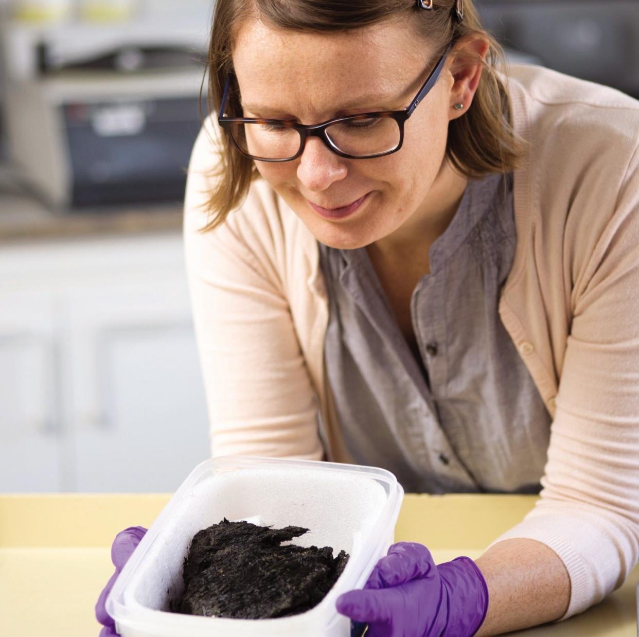 Researcher with box of remains from site