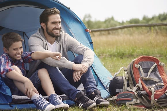 Man and boy sitting in front of tent