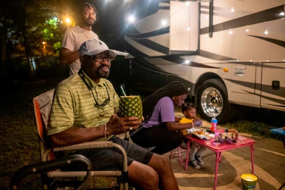 Dr. Stewart Darby, a Columbia, S.C. physician enjoys a pineapple drink while camping with his family on his empty lot in Atlantic Beach and watching the bikers on a Friday night.