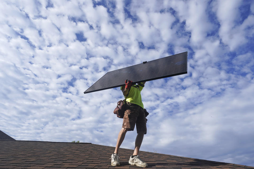 A workman from Power Shift Solar installs a solar panel Thursday, Aug. 11, 2022, in Salt Lake City. Congress is poised to pass a transformative climate change bill on Friday, Aug. 12. The crux of the long-delayed bill is to use incentives to accelerate the expansion of clean energy such as wind and solar power, speeding the transition away from the oil, coal and gas that largely cause climate change. (AP Photo/Rick Bowmer)