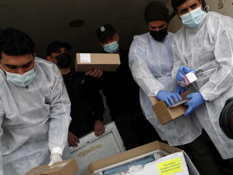 Medics and police officers check a shipment of the Russian Sputnik V vaccine inside a truck at the Kerem Shalom border crossing, in Rafah, Gaza Strip, Wednesday, Feb. 17, 2021. The Palestinian Authority said Wednesday that it dispatched the first shipment of coronavirus vaccines to the Hamas-ruled Gaza Strip, two days after accusing Israel of preventing it from sending the doses amid objections from some Israeli lawmakers. (AP Photo/Adel Hana)