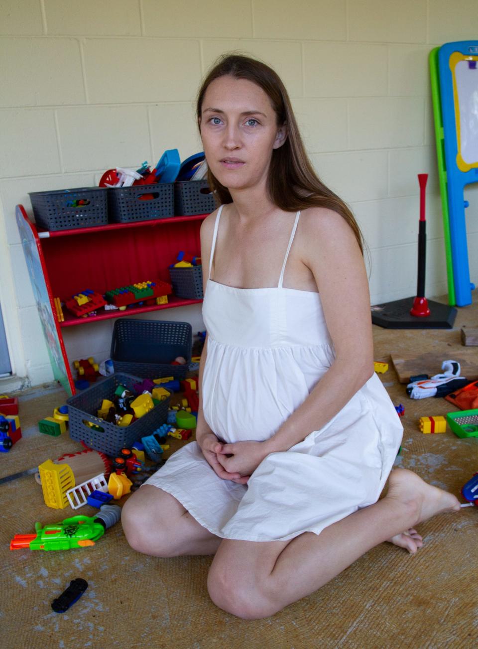 Deborah Dorbert kneels on the patio of her Lakeland home, amid her 4-year-old son's toys. Dorbert, 33, learned during her second pregnancy that her fetus had abnormalities and would die soon after birth. She wanted to terminate her pregnancy, but doctors at Lakeland Regional Health said abortion restrictions passed last year in Florida prevented them from performing the procedure after 15 weeks of pregnancy.