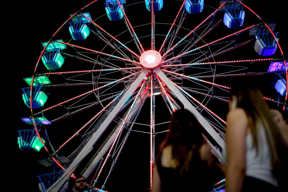 People look at a ride while waiting in line at the 2023 Oklahoma State Fair in Oklahoma City.