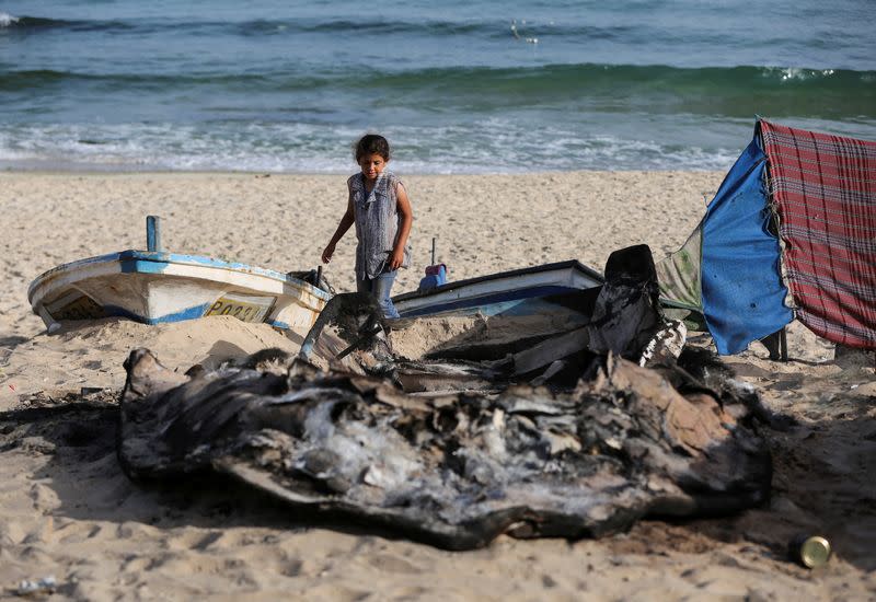 Palestinians inspect boats damaged in Israeli fire, in Rafah in the southern Gaza Strip