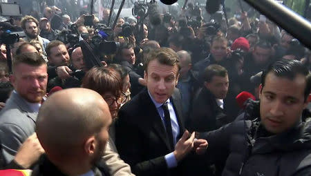 A still image taken from video show Emmanuel Macron (C), head of the political movement En Marche !, or Onwards !, and candidate for the 2017 French presidential election, talking to Whirlpool employees in front of the company plant in Amiens, France, April 26, 2017. REUTERS/REUTERS TV