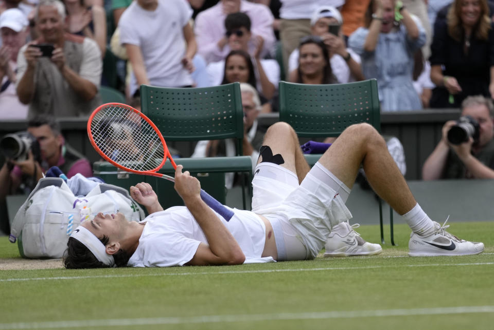 Taylor Fritz of the US lays on the court after falling trying to return to Spain's Rafael Nadal in a men's singles quarterfinal match on day ten of the Wimbledon tennis championships in London, Wednesday, July 6, 2022. (AP Photo/Kirsty Wigglesworth)