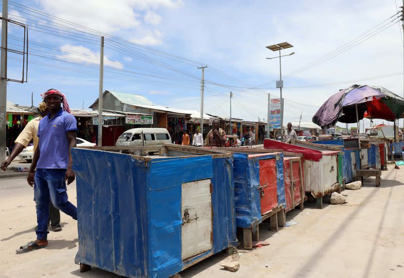 Residents walk past closed khat stimulants stalls, amid concerns about the spread of coronavirus disease (COVID-19), in Mogadishu