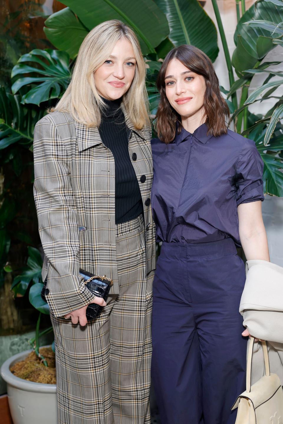 Abby Elliott (in Tory Burch's plaid wool jacket and pant, and Eleanor embossed bag) with Caplan.