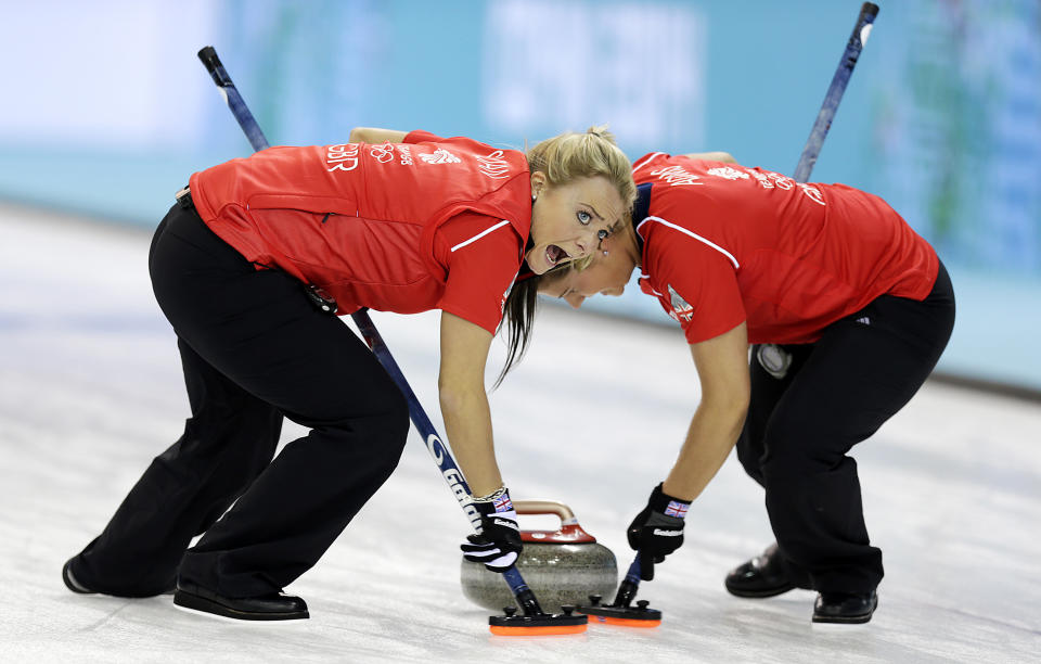 Great Britain's Anna Sloan, left, and Vicki Adams, right, sweep the ice during the women's curling competition against the United States at the 2014 Winter Olympics, Tuesday, Feb. 11, 2014, in Sochi, Russia. 