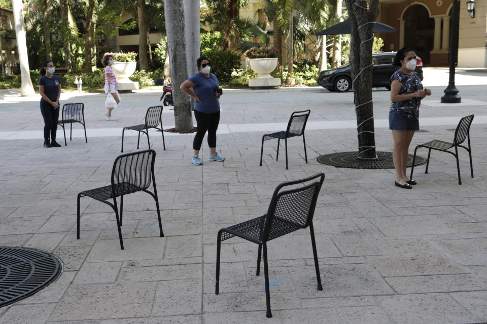 People practice social distancing as they wait in line for a complimentary meal at Someone's Son restaurant, during new coronavirus pandemic, Wednesday, April 22, 2020, in Coral Gables, Fla. (Lynne Sladky/AP)