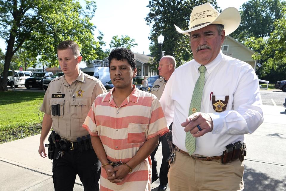 Francisco Oropeza, center, is escorted to the San Jacinto County courthouse by San Jacinto County Sheriff Greg Capers, right, for a hearing Thursday, May 18, 2023, in Coldspring, Texas. Oropeza is suspected of killing five people, including a 9-year-old boy, after neighbors asked him to stop firing off rounds in his yard. (AP Photo/David J. Phillip)