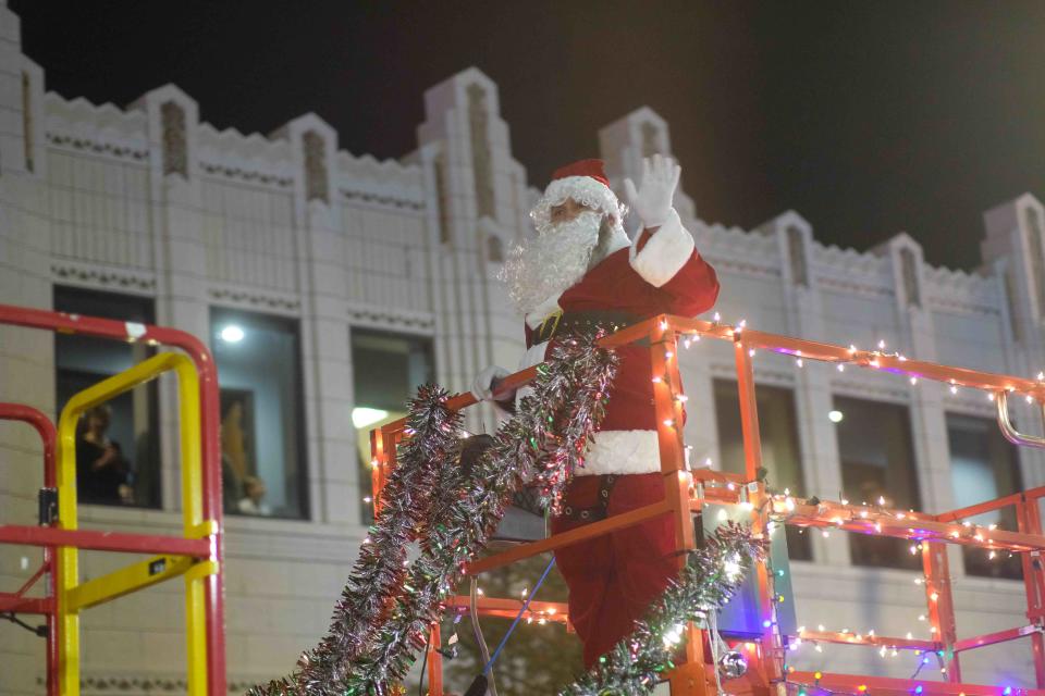 Santa brings the kids to their feet as he waves to the crowd on Polk Street  Friday night during the Center City Electric Light Parade in downtown Amarillo.