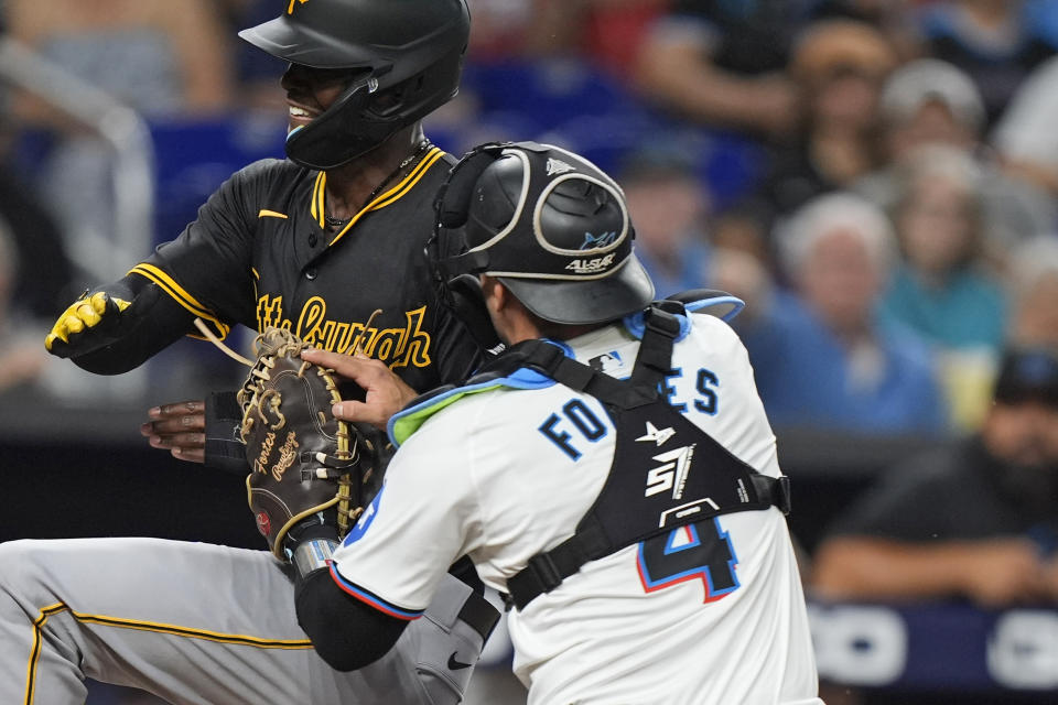 Miami Marlins catcher Nick Fortes (4) tags out Michael A. Taylor at home during the 11th inning of a baseball game, Thursday, March 28, 2024, in Miami. (AP Photo/Wilfredo Lee)