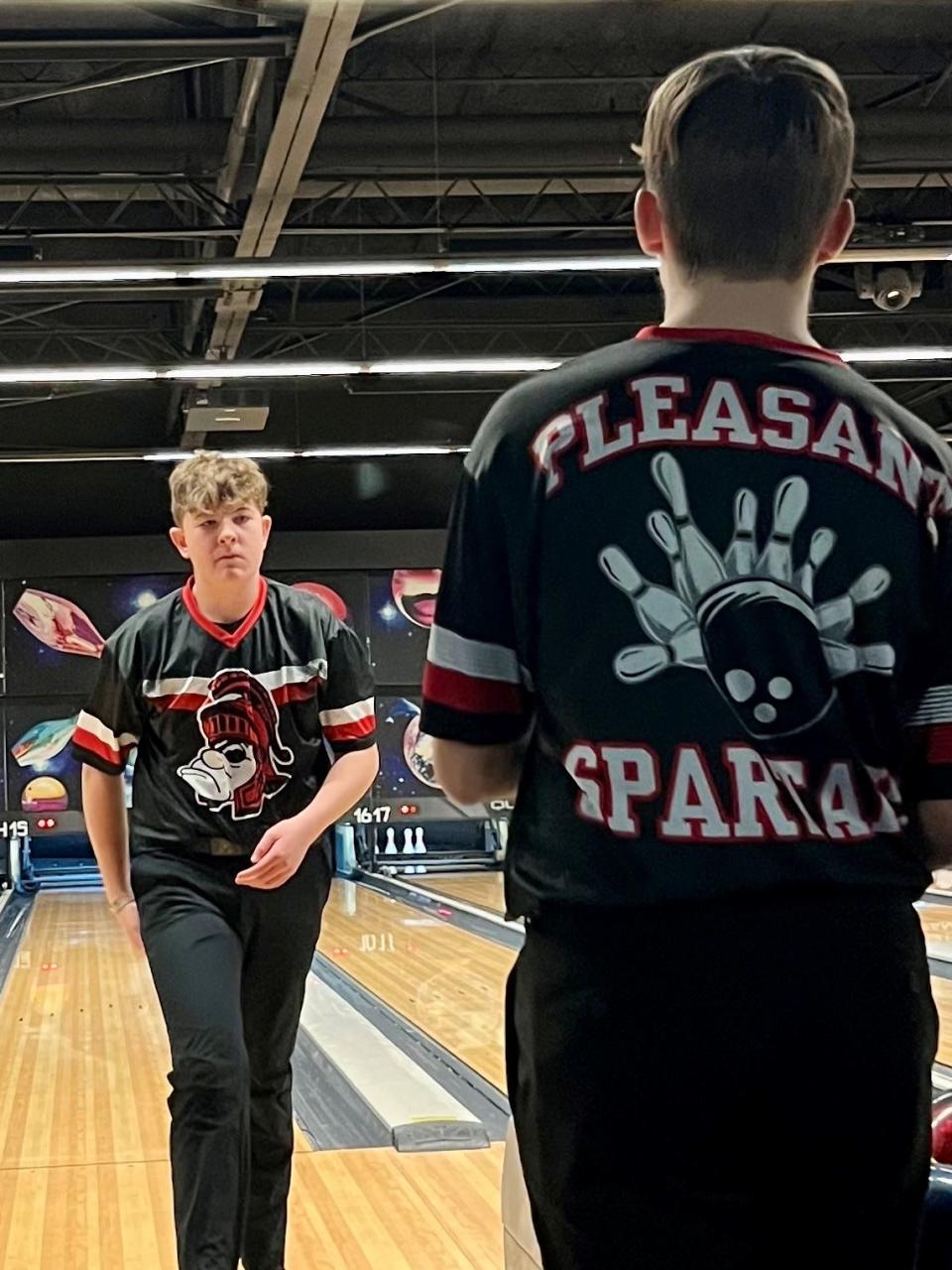 Pleasant's Dawson Hall walks back as Nolan Ludwig gets set to roll during a boys bowling batch last year with River Valley at Bluefusion Entertainment.