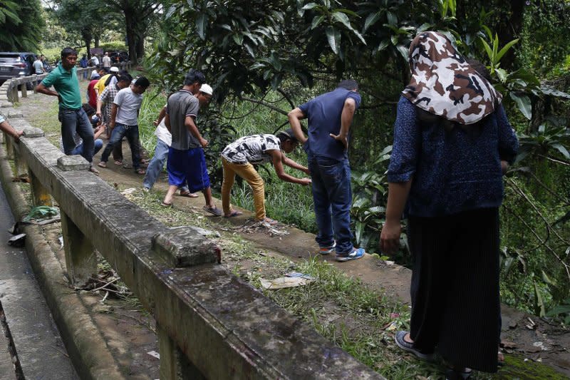 8名馬拉威市的居民被發現陳屍排水道，眾人正準備合力將遺體拉上來。（美聯社）