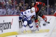 Tampa Bay Lightning defenseman Mikhail Sergachev (98) and New Jersey Devils center Dawson Mercer battle for the puck during the second period of an NHL hockey game Tuesday, March 14, 2023, in Newark, N.J. (AP Photo/Adam Hunger)