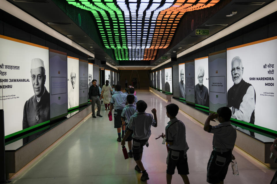 School children walk in a queue inside the corridor of "Pradhanmantri Museum," or Prime Minister Museum, featuring photographs of India's present and past prime ministers in New Delhi, India, Wednesday, Aug. 3, 2022. Seen on left is India's first Prime Minister Jawaharlal Nehru and on right is current Prime Minister Narendra Modi. (AP Photo/Altaf Qadri)