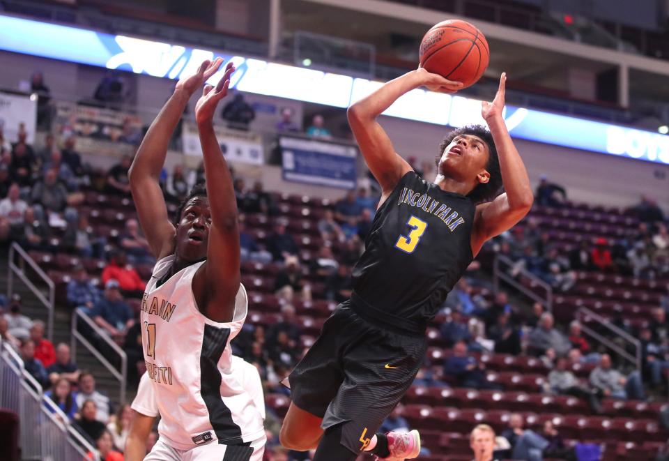 Lincoln Park's Brandin Cummings (3) goes for two points after tripping up Neumann-Goretti's Sultan Adewale (11) during the first half of the PIAA 4A Championship game Thursday night at the Giant Center in Hershey, PA.