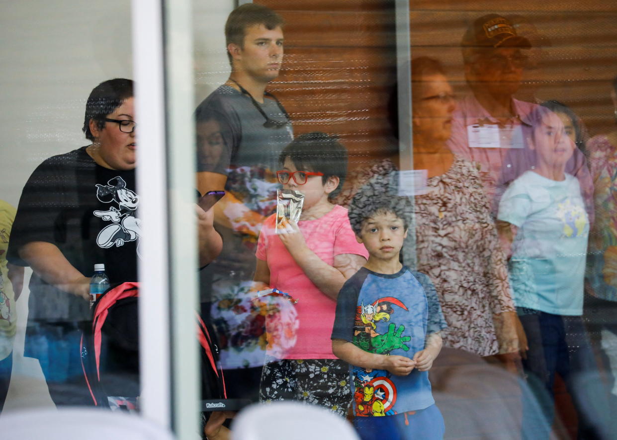 A child looks on through a window from inside a reunification center where students had been transported after the mass shooting at Robb Elementary School in Uvalde, Texas, on Tuesday. 