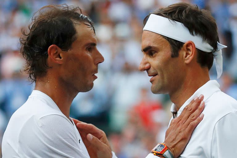 2 de julio de 2019. El suizo Roger Federer (der.) le da la mano y abraza al español Rafael Nadal (izq.) después de que Federer ganara su partido de semifinales de individuales masculino el día 11 del Campeonato de Wimbledon 2019 en The All England Lawn Tennis Club en Wimbledon, al suroeste de Londres. 