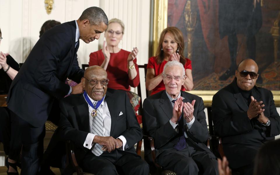 U.S. President Barack Obama places a Presidential Medal of Freedom around the neck of golfer Charles Sifford (front L) as fellow recipients economist Robert Solow (2nd R), singer Stevie Wonder (R), actress Meryl Streep (C-Rear) and actress Marlo Thomas (R-Rear) applaud during a ceremony in the East Room of the White House in Washington, November 24, 2014. (REUTERS/Larry Downing)