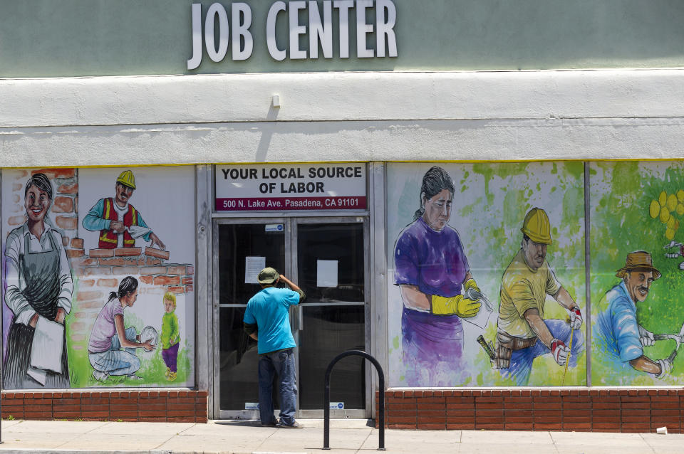 FILE - In this May 7, 2020, file photo, a person looks inside the closed doors of the Pasadena Community Job Center in Pasadena, Calif., during the coronavirus outbreak. On Thursday, Aug. 20, the government reported that the number of workers applying for unemployment climbed back over 1 million last week after two weeks of declines. (AP Photo/Damian Dovarganes, File)