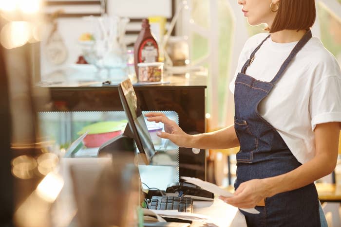 cashier's hands typing on a screen