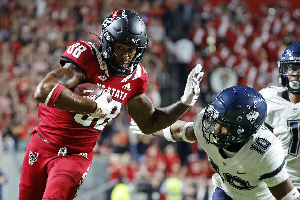 North Carolina State's Devin Carter (88) prepares to stiff-arm Connecticut's Chris Shearin (10) following a reception during the first half of an NCAA college football game in Raleigh, N.C., Saturday, Sept. 24, 2022. (AP Photo/Karl B DeBlaker)