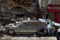 FILE - People inspect their car that was damaged in Tuesday's massive explosion in the seaport of Beirut, Lebanon, Wednesday, Aug. 5, 2020. Lebanon’s top prosecutor Wednesday, Jan. 25, 2023, ordered all suspects detained in the deadly 2020 port blast in Beirut released, a lawyer for two detainees and judicial officials said. (AP Photo/Bilal Hussein, File)