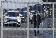 A motorcade with police cars and busses with passengers from the Ukrainian aircraft chartered by the Ukrainian government for evacuation from the Chinese city of Wuhan, leave the the gate upon their landing at airport outside Kharkiv, Ukraine, Thursday, Feb. 20, 2020. Ukraine's effort to evacuate more than 70 people from China due to the outbreak of the new COVID-19 virus was delayed because of bad weather as evacuees travel to a hospital where they are expected to be quarantined. (AP Photo/Igor Chekachkov)