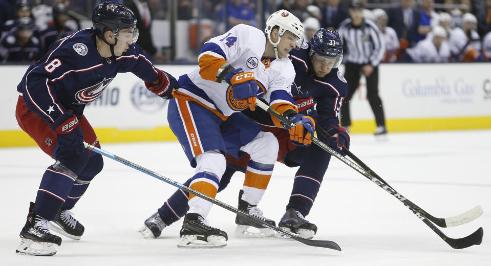 New York Islanders' Tom Kuhnhackl, center, of Germany, skates between Columbus Blue Jackets' Zach Werenski, left, and Markus Hannikainen, of Finland, during the first period of an NHL hockey game Thursday, Feb. 14, 2019, in Columbus, Ohio. (AP Photo/Jay LaPrete)