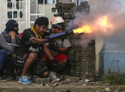 An anti-government demonstrator fires a home-made mortar during clashes with riot police at a barricade in the town of Masaya on June 9, 2018