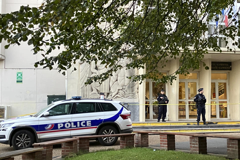 Police officers stand guard outside the high school where a man stabbed a teacher, Saturday Oct.14, 2023 in Arras, northern France. A man of Chechen origin who was under surveillance by French security services over suspected Islamic radicalization stabbed a teacher to death at his former high school and wounded three other people Friday in Arras. (AP Photo/Jeffrey Schaeffer)