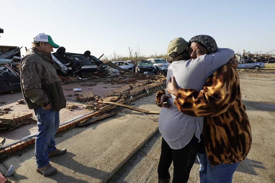 Tracy Hardin, center, who with her husband Tim, left, own Chuck's Dairy Bar, consoles a neighbor in Rolling Fork, Miss., Saturday, March 25, 2023. The couple and their six employees were hiding in the cooler when the tornado hit. (AP Photo/Rogelio V. Solis)