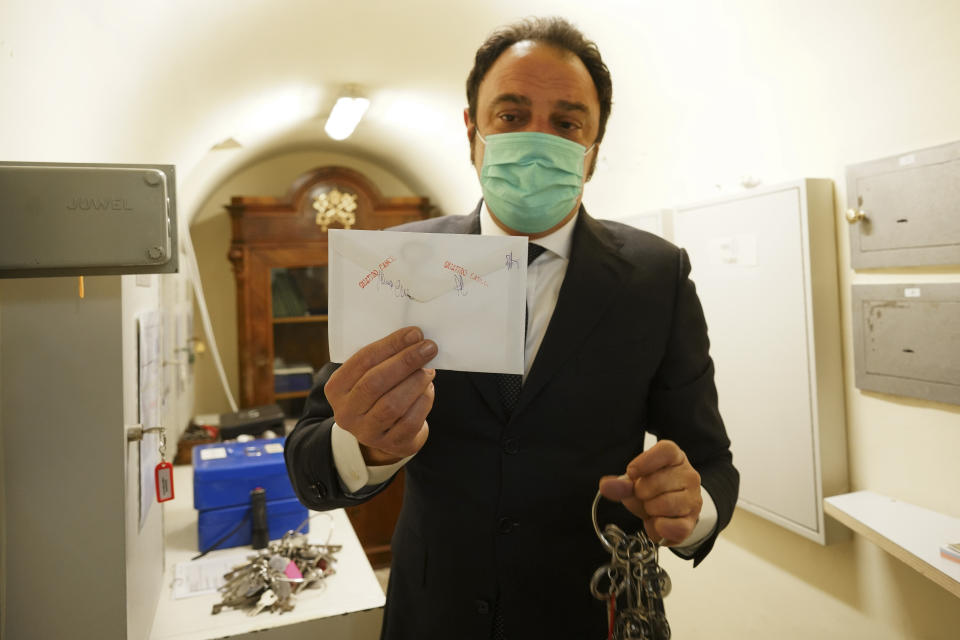 Gianni Crea, the Vatican Museums chief "Clavigero" key- keeper, shows the sealed envelope where the 19th century key of the Sistine Chapel is kept, in the a safe where the museum's keys are kept, as he prepares to open it, at the Vatican, Monday, Feb. 1, 2021. Crea is the “clavigero” of the Vatican Museums, the chief key-keeper whose job begins each morning at 5 a.m., opening the doors and turning on the lights through 7 kilometers of one of the world's greatest collections of art and antiquities. The Associated Press followed Crea on his rounds the first day the museum reopened to the public, joining him in the underground “bunker” where the 2,797 keys to the Vatican treasures are kept in wall safes overnight. (AP Photo/Andrew Medichini)