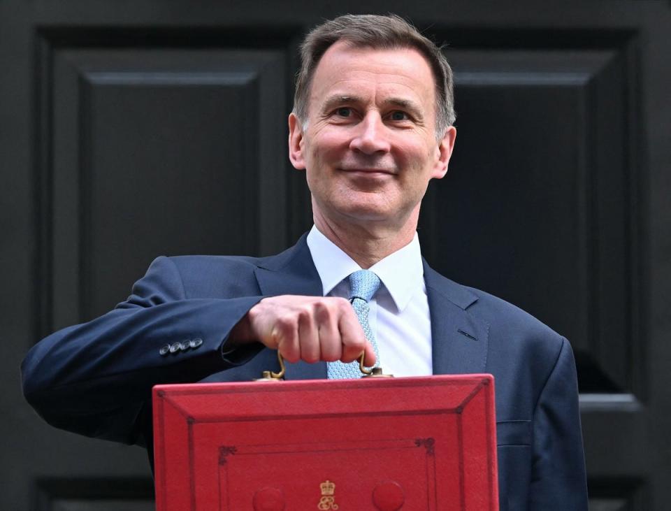 Jeremy Hunt poses with the red Budget box, 6 March 2024 (AFP via Getty Images)