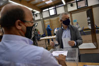 Inigo Urkullo, Basque Lehendakari or Regional President, right, wears a face mask as protection against the coronavirus while voting in a polling station during Basque regional election in the village of Durango, northern Spain, Sunday, July 12, 2020. (AP Photo/Alvaro Barrientos)