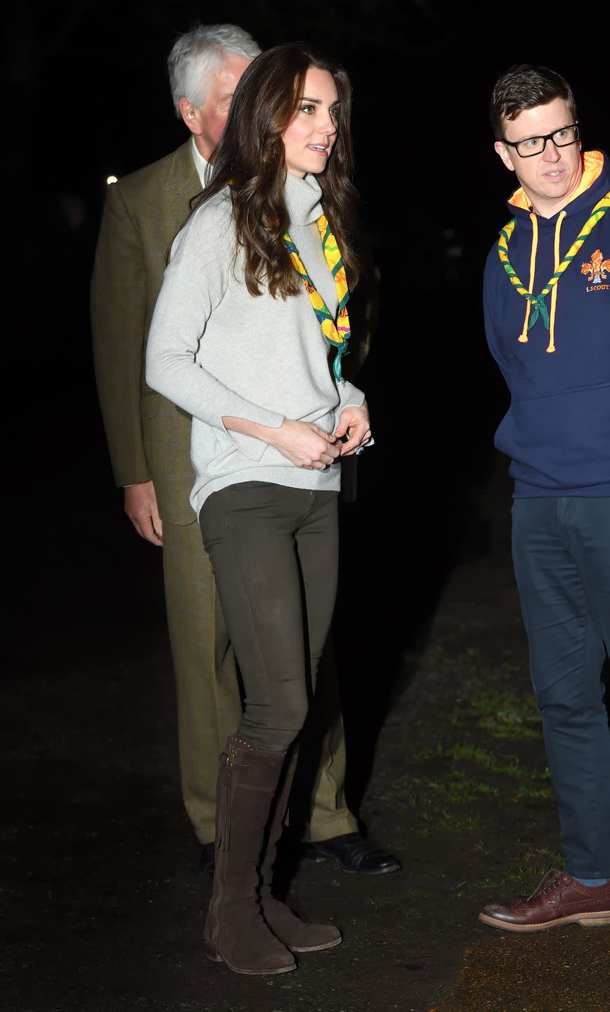 <p>The Duchess wears a heather grey turtleneck sweater, dark olive pants, knee-high brown suede boots with tassels and a Cub Scout kerchief during an official visit to a Cub Scout Pack Meeting in King's Lynn, England.</p>