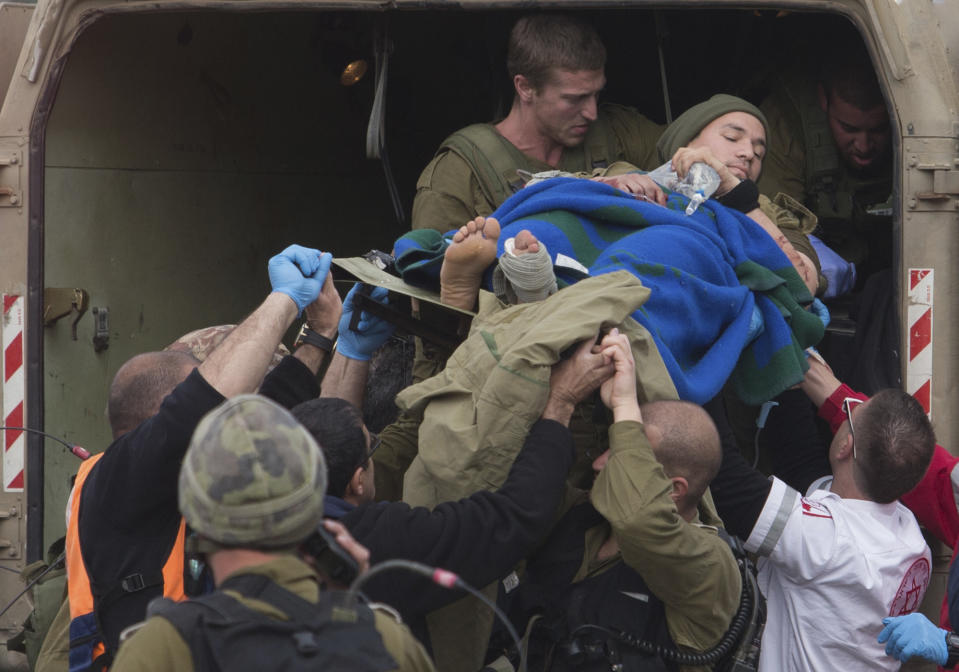 A wounded Israeli soldier is brought to a soccer field to be evacuated to a hospital, in the village of Masade in the Golan Heights, Tuesday, March 18, 2014. A roadside bomb hit an Israeli patrol near the frontier with the Golan Heights on Tuesday, the army said, wounding four soldiers in the most serious violence to strike the area since the Syrian conflict began three years ago. Israel said it responded with artillery strikes on Syrian army targets. Israel captured the Golan Heights from Syria in the 1967 Middle East war and later annexed the strategic area in a move that was not internationally recognized. (AP Photo/Jinipix) ****ISRAEL OUT***