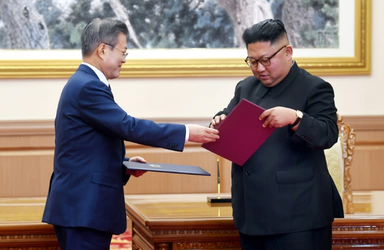 South Korean President Moon Jae-in exchanges documents with North Korean leader Kim Jong Un after their summit in Pyongyang