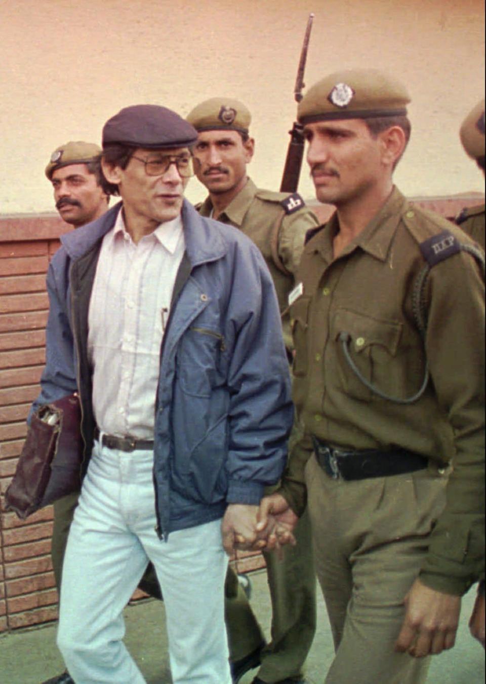 Charles Sobhraj, a.k.a The Serpent, is escorted by police to a court in New Delhi, India, in 1997.