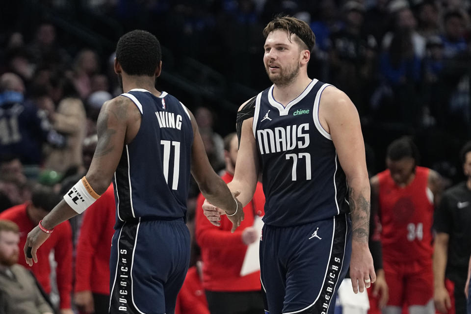 Dallas Mavericks guard Kyrie Irving (11) gives a hand to guard Luka Doncic (77) during the first half of the team's NBA basketball game against the Portland Trail Blazers in Dallas, Wednesday, Jan. 3, 2024. (AP Photo/LM Otero)