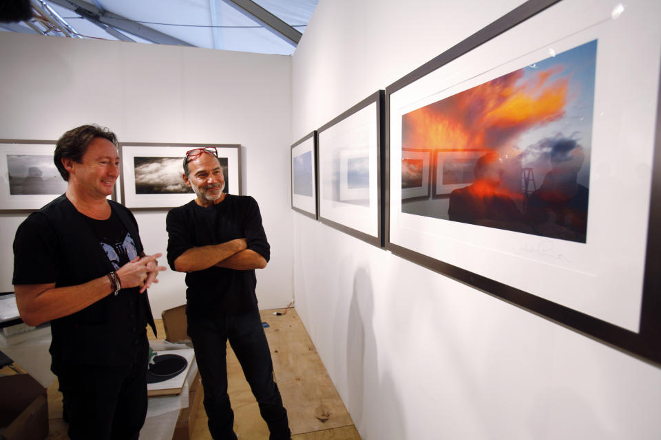 Julian Lennon, son of the late Beatles legend John Lennon, left, and and his friend, celebrity photographer Timothy White look over some of the photographs Lennon is displaying in a show titled “Alone” at the Overture Art Fair, Monday, Dec. 3, 2012 in Miami during an interview with The Associated Press. Art Basel Miami Beach and about two dozen other independent art fairs open Thursday. Tens of thousands of people are expected through Sunday at the fairs throughout Miami and South Beach. Lennon also exhibited his photography during the 2010 art fairs, and he was looking forward to enjoying Miami’s social scene. “You get every kind of character and every kind of style,” he said. “I just hope that doesn’t detract from the actual work of the artists who’ve come here.” (AP Photo/Wilfredo Lee)