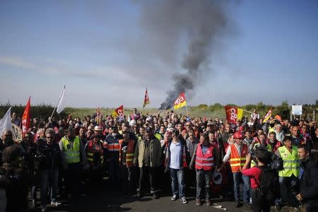 Striking French CGT labour union employees stand near a burning barricade before a police operation to free up a fuel depot near the Donges oil refinery as workers protest the labour reforms law proposal in Donges, France, May 27, 2016. REUTERS/Stephane Mahe